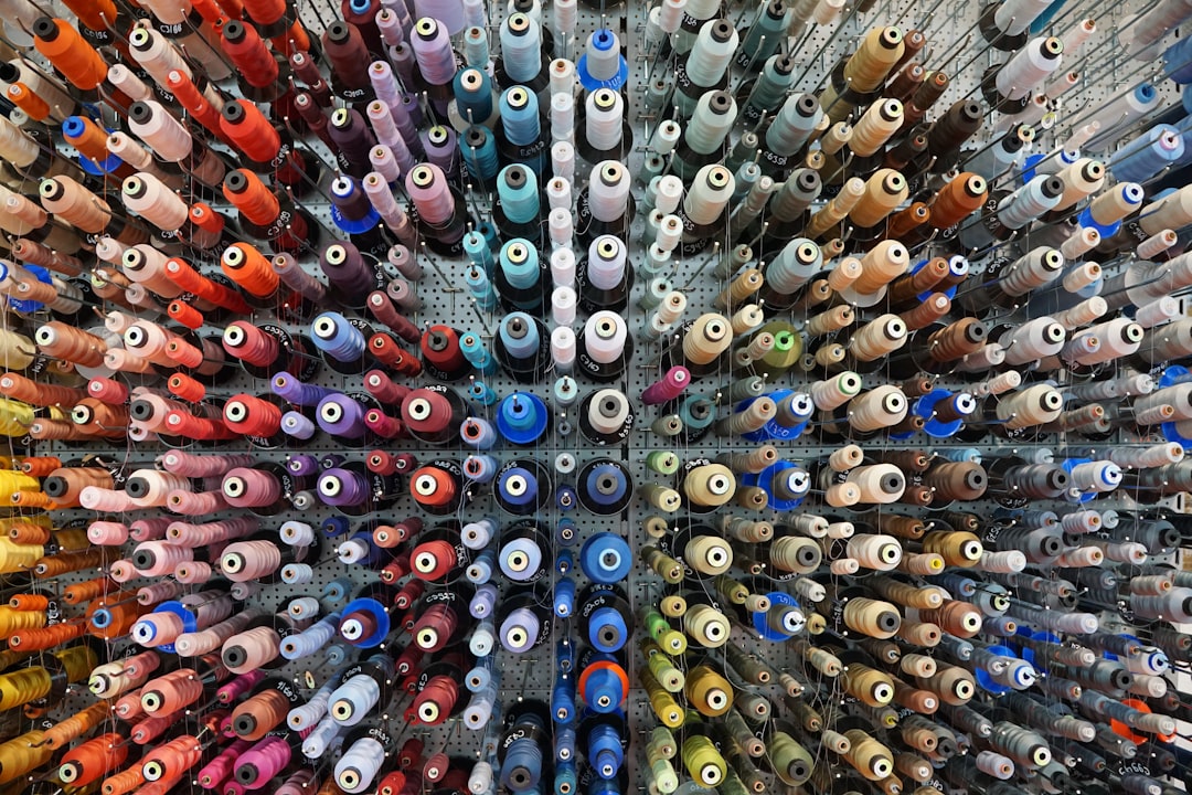 A collection of sewing thread spools displayed in a clothing repair workshop.